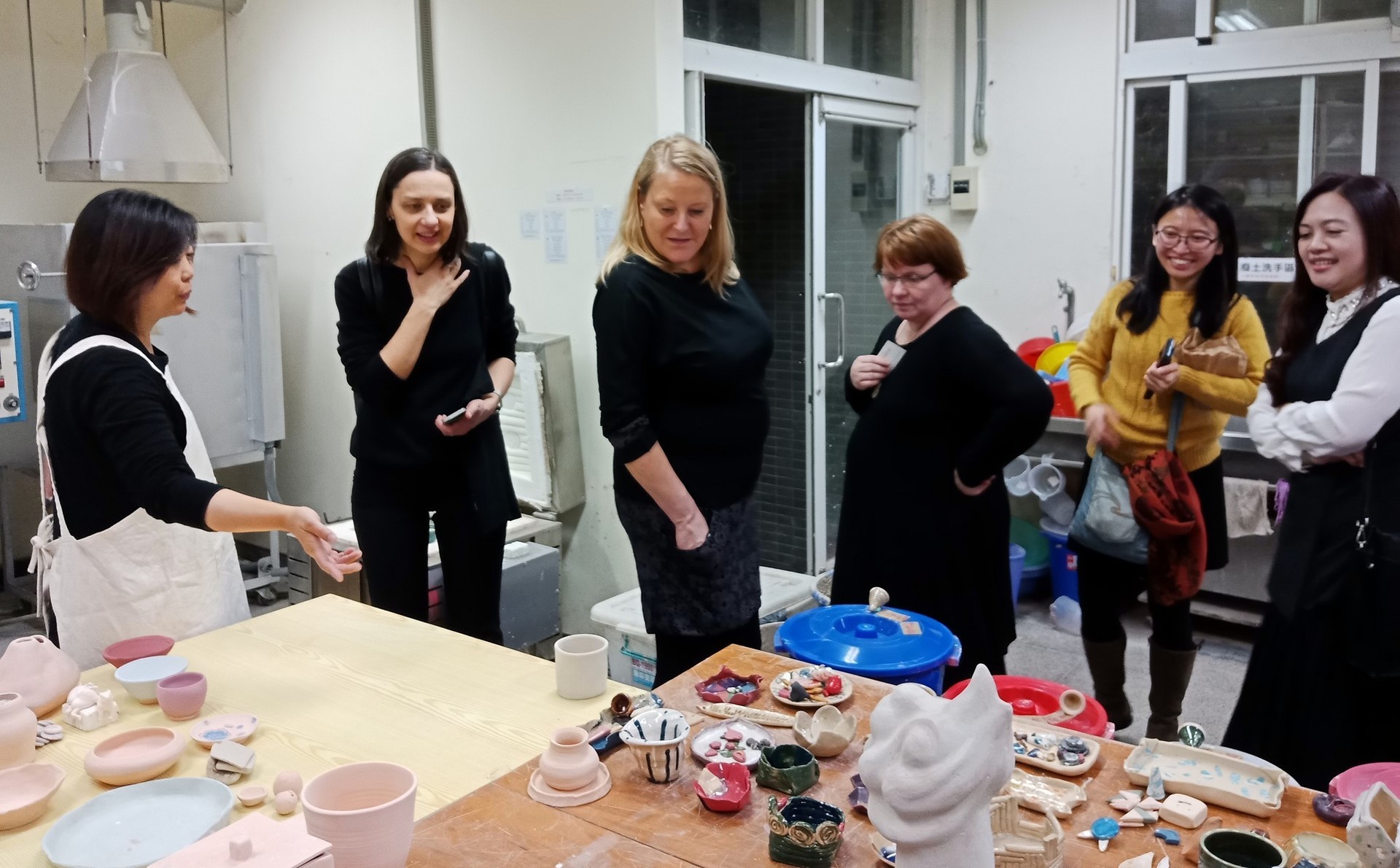 藝術創意產業學系王昱心教授與學者Magdalena Kmak（左二）、Reetta Toivanen（左三）、Pigga Keskitalo（右三）介紹陶藝工坊