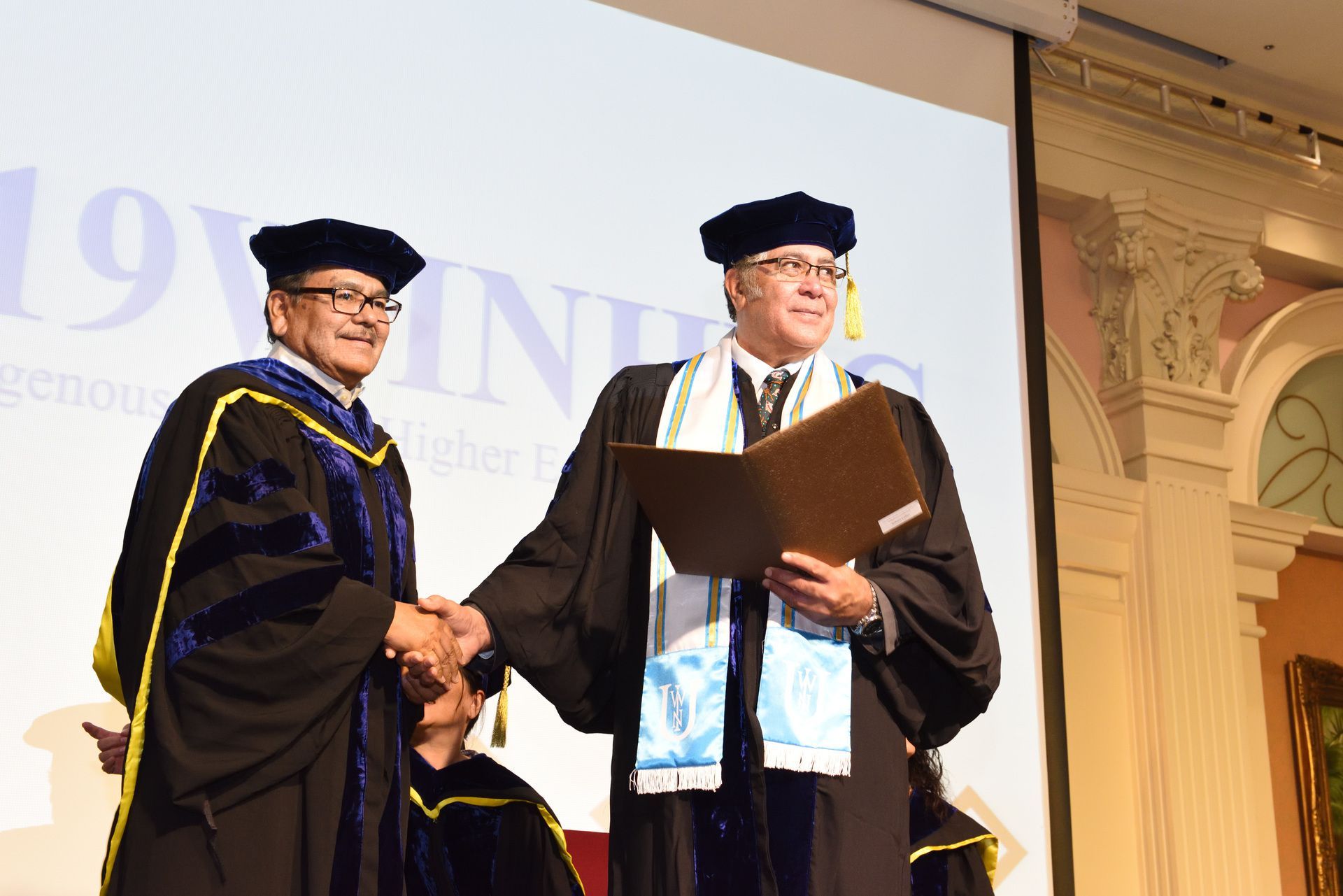WINHEC 共同主席Dr. Elmer Guy (圖左)頒發榮譽領袖獎項給前任共同主席紐西蘭籍的Dr. Hohaia Collier (圖右)。Dr. Collier 於今年接任世界原住民族大學校長