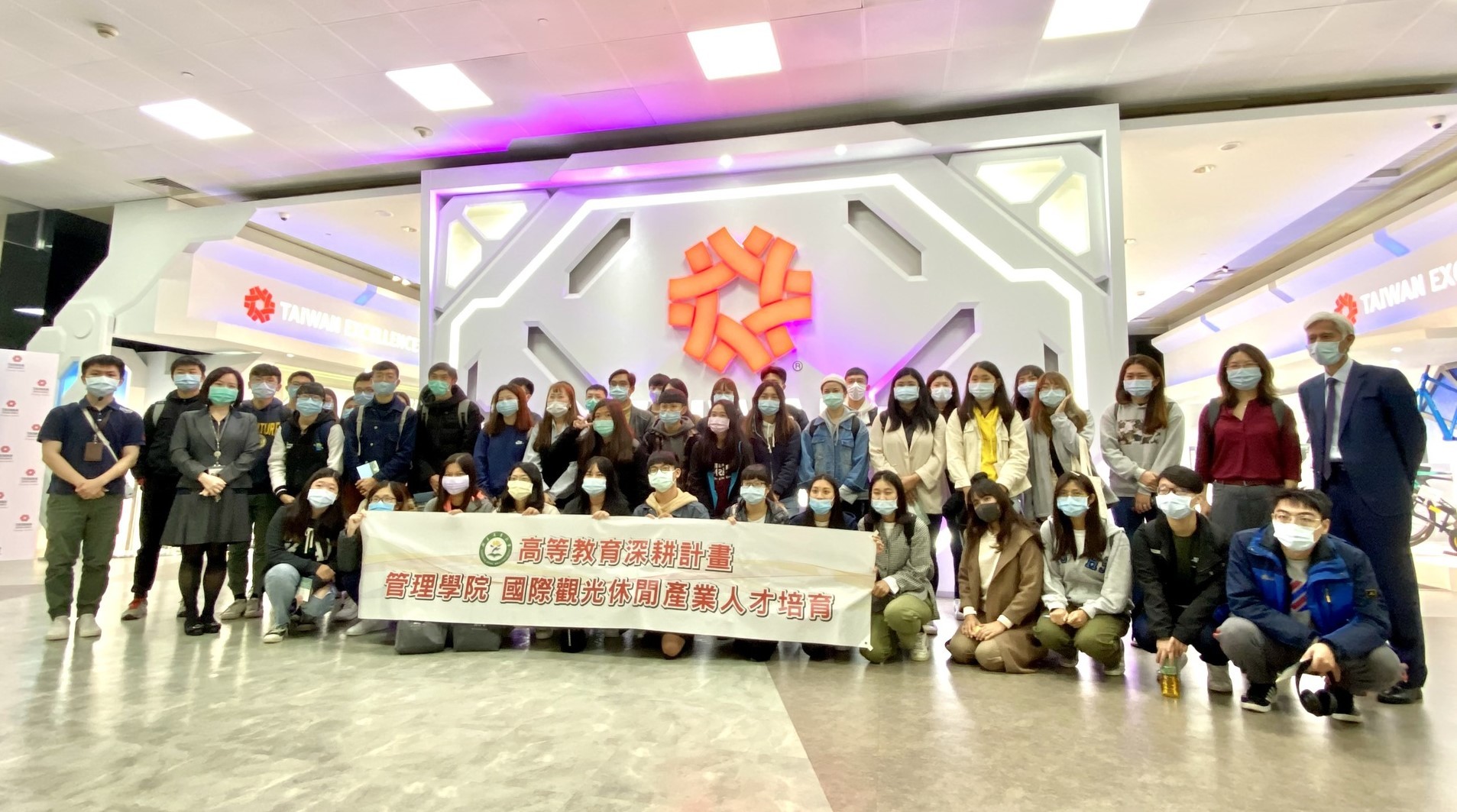 東華大學觀遊系參訪師生與中心代表於南港展覽中心臺灣精品館前合影,(右後一)羅明植主任、(右後二)東華大學陳麗如主任、(左三)傅勻嫚組長
