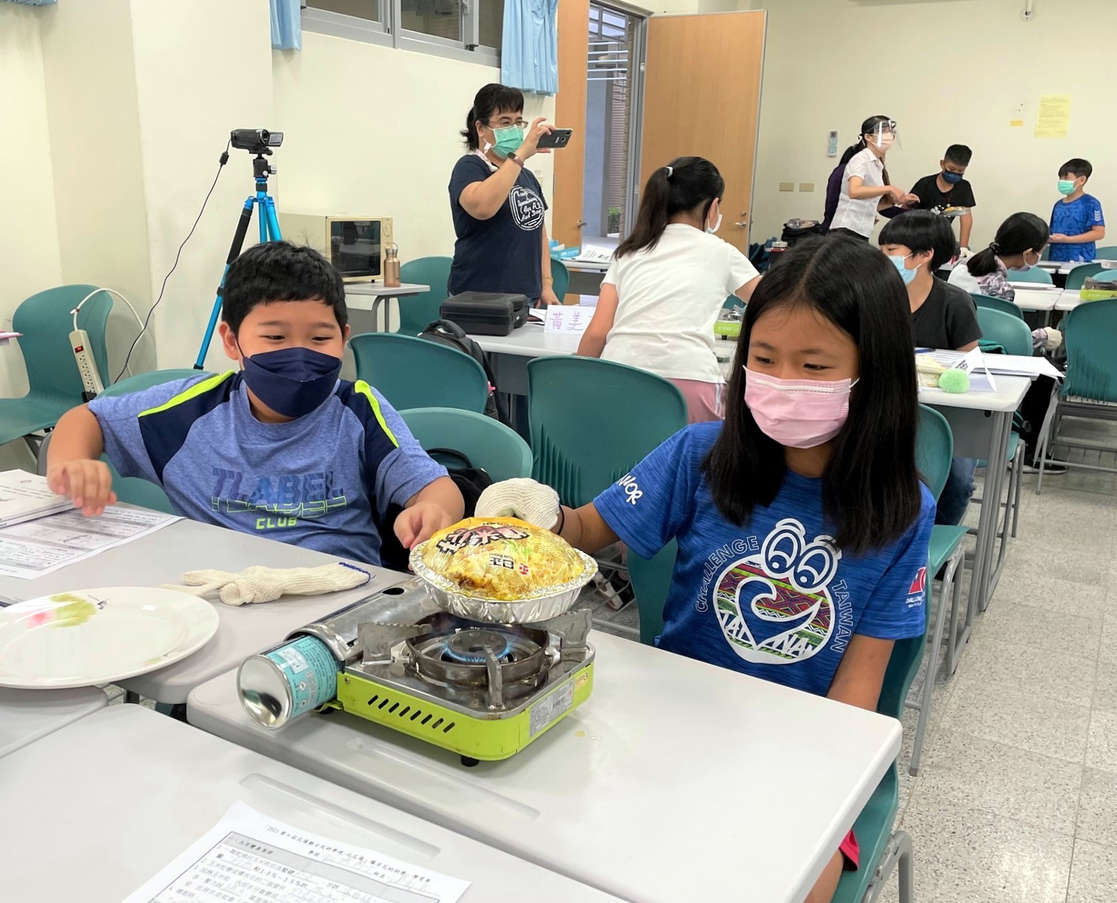 學員們進行「爆米花的科學」動手做教案,看到爆米花爆開露出開心的笑顏。
