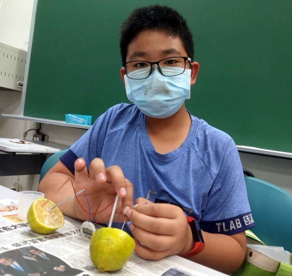 學員展示自己在「食物發電」動手做教案中製作的水果發電裝置。