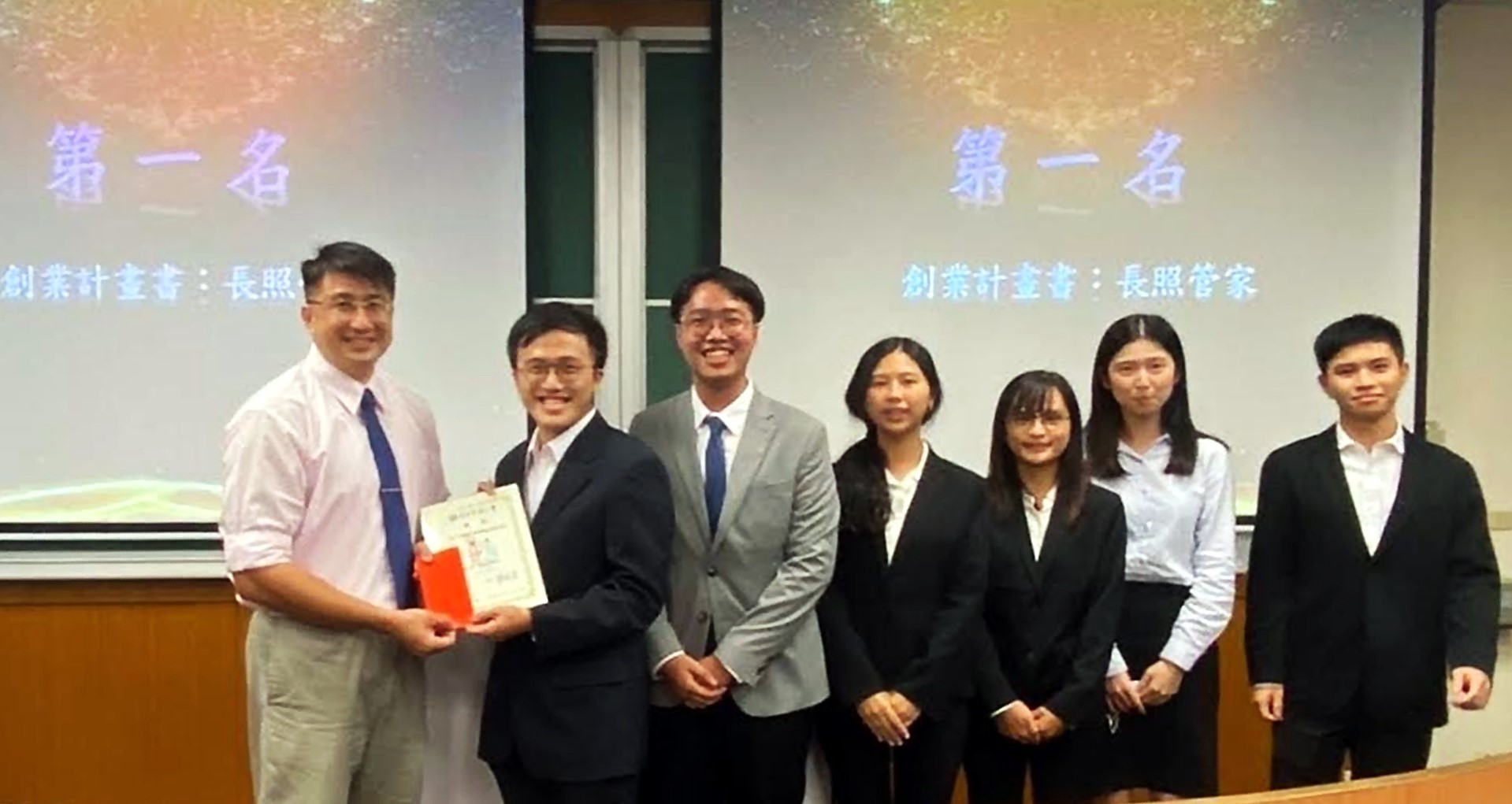 國企系主任欒錦榮老師頒獎，恭喜第一名的專題團隊成員