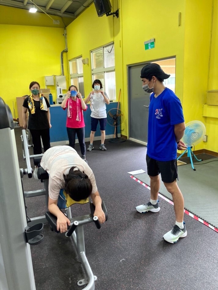 重量訓練班指導教練張宇琛老師教導學員使用健身器材。