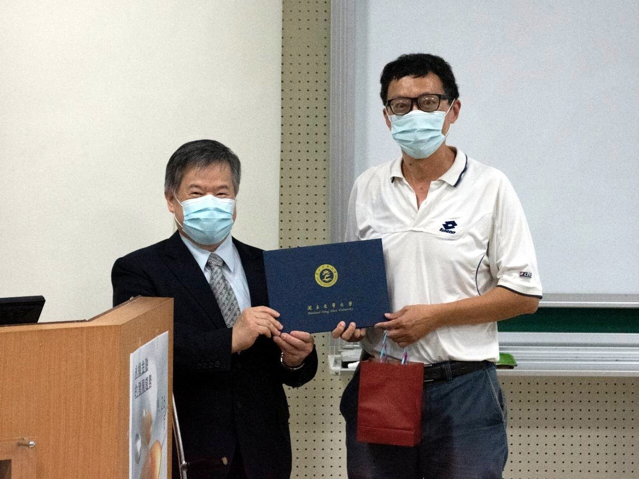 吳中書董事長接受由張伯浩教授代表頒贈之感謝狀與禮品