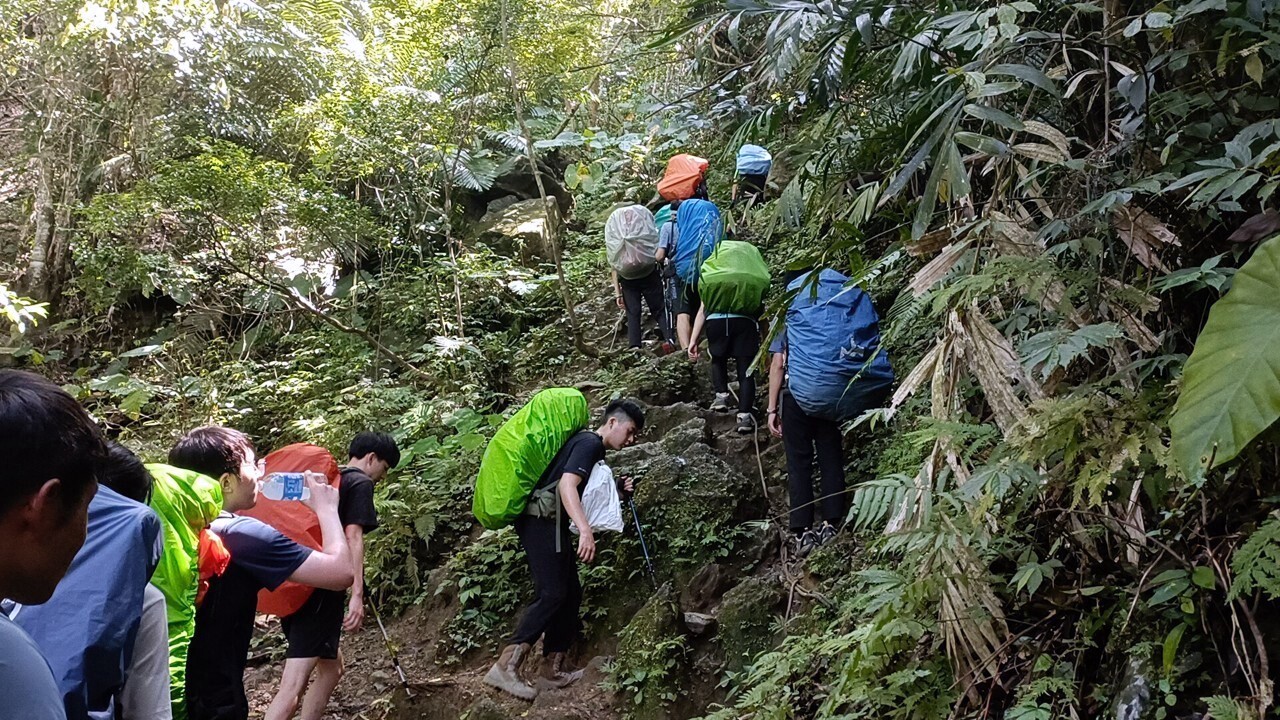 背負重裝走在原始山林路徑