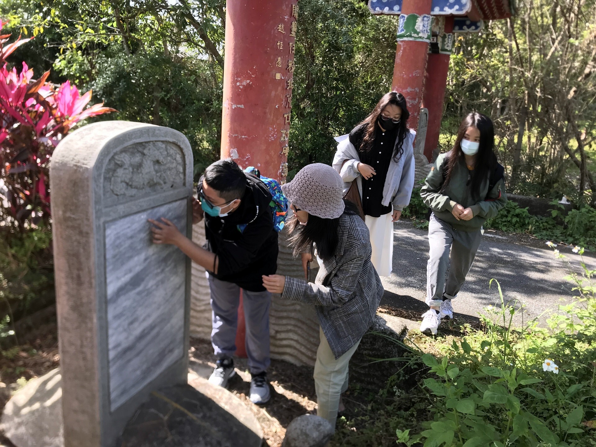 小組學生研究光華村牌樓旁石碑上的文史紀錄