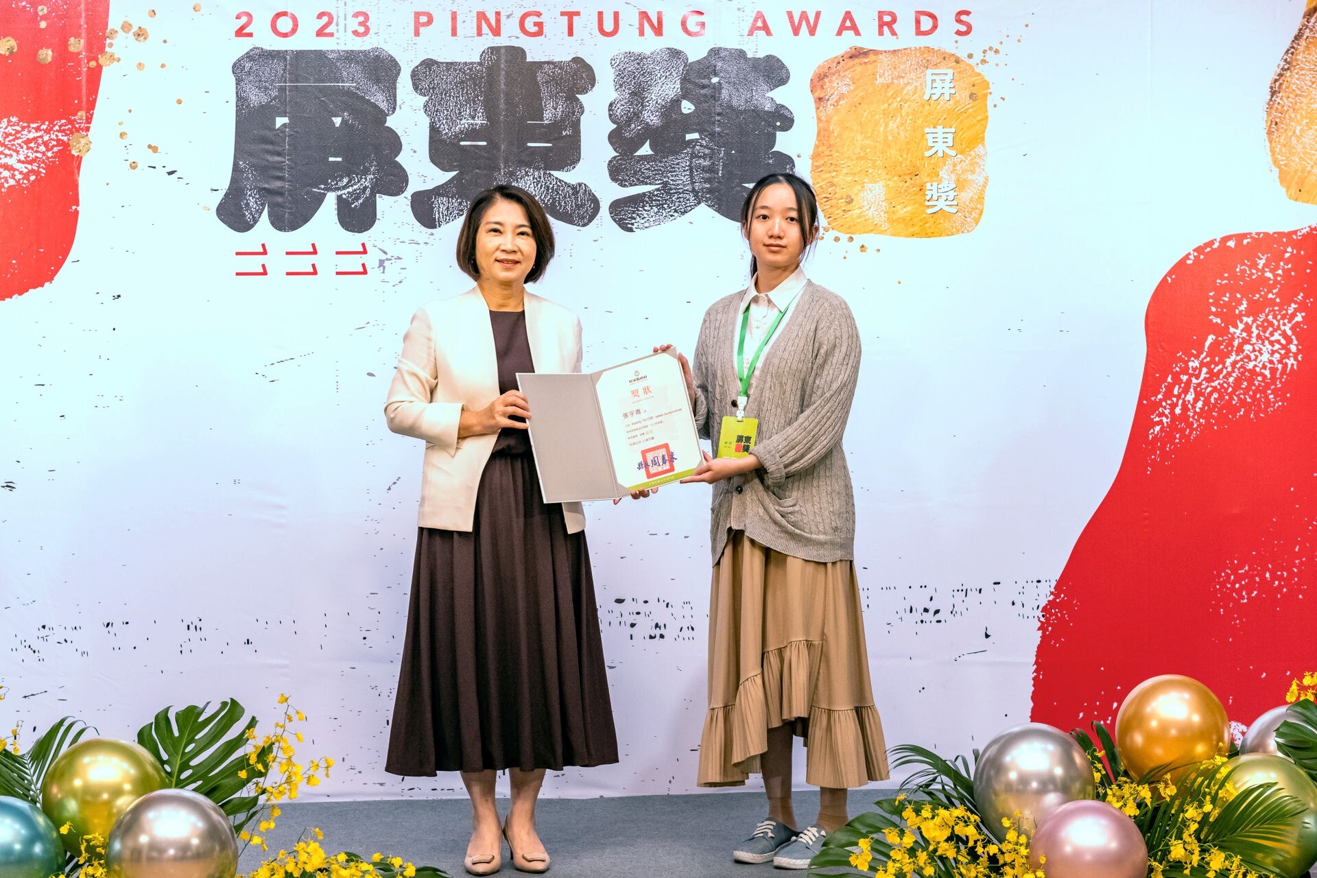創作者張宇青同學(右)於屏東美術館接受屏東縣長周春米(左)親頒優選獎狀