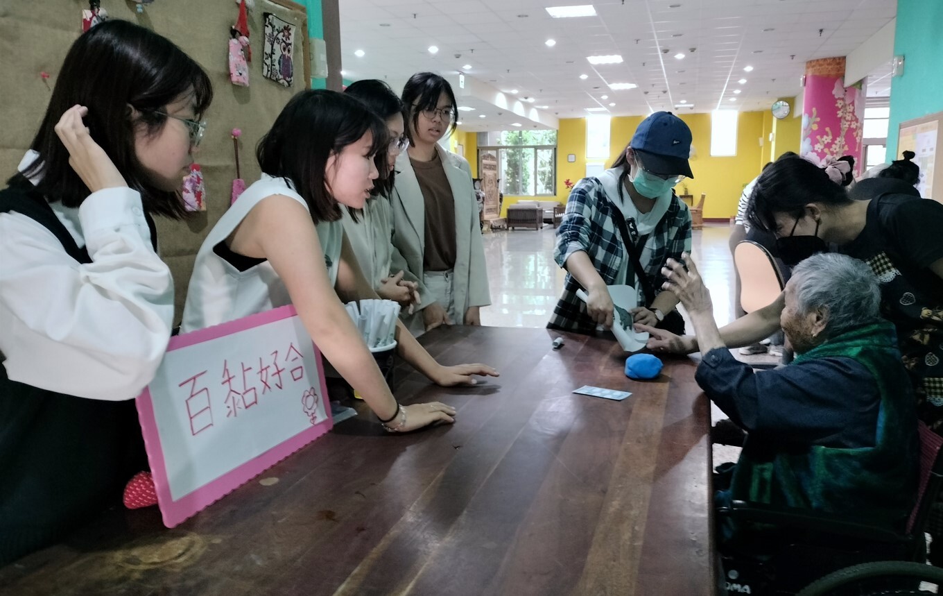 學生協助長者根據自己抽到的圖樣捏黏土,桌上放著闖關卡