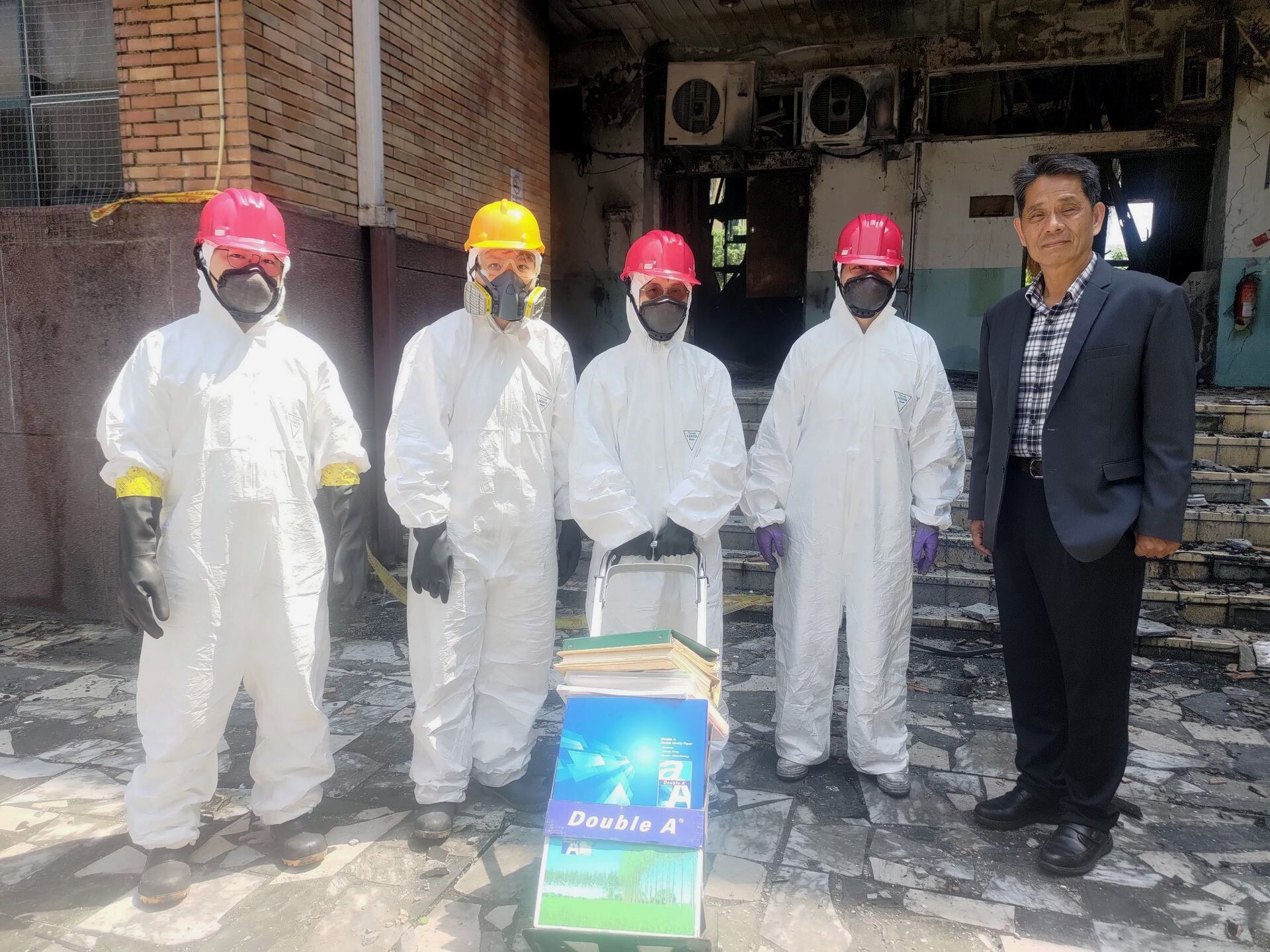徐輝明校長於理工學院一館D棟損毀實驗室前關切學生著防護裝清理實驗室