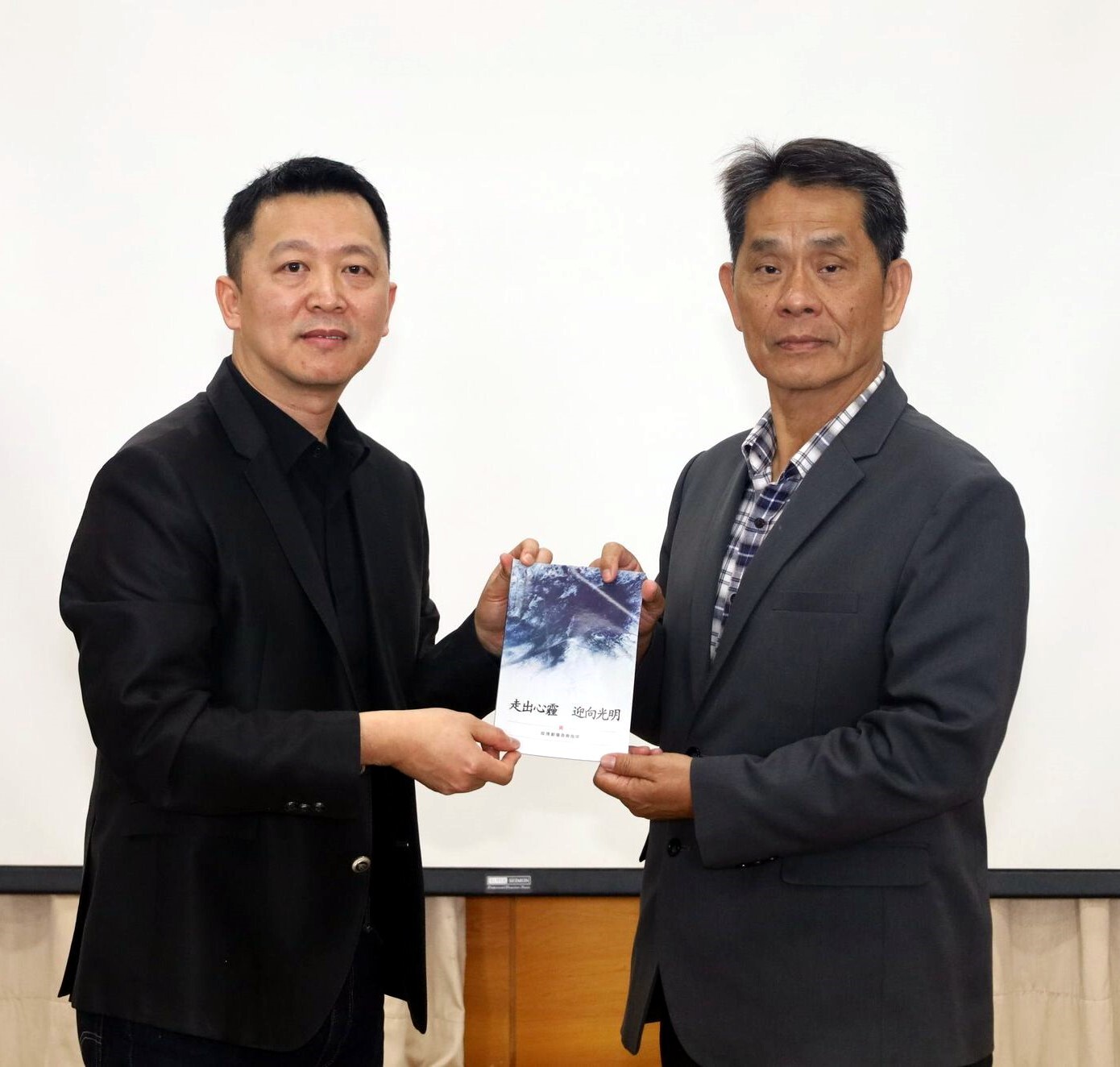 徐輝明校長代表接受花蓮美崙浸信會蔡志堅主任牧師致贈聯合聖經公會出版之「走出心霾 迎向光明」手冊,希冀對安撫大家心靈有所裨益