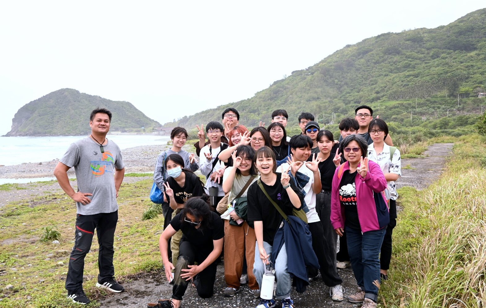 陳科睿經理(左一)與師生合照,背景是師生剛走過的磯崎海岸