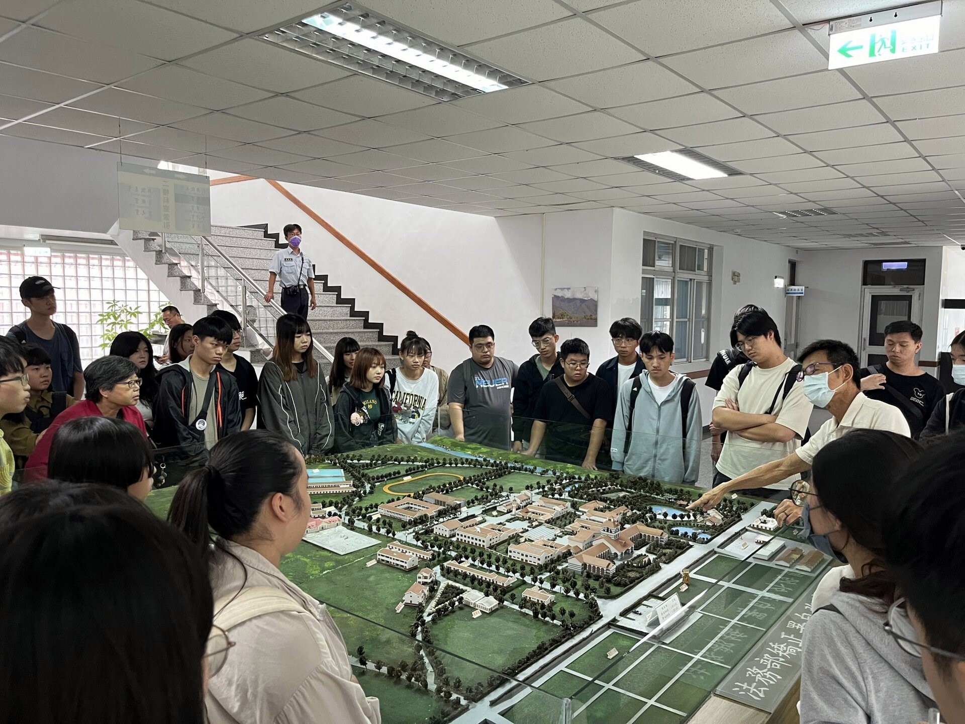 曾富良科長(右邊戴口罩者)以自強外役監模型向學生說明園區空間配置