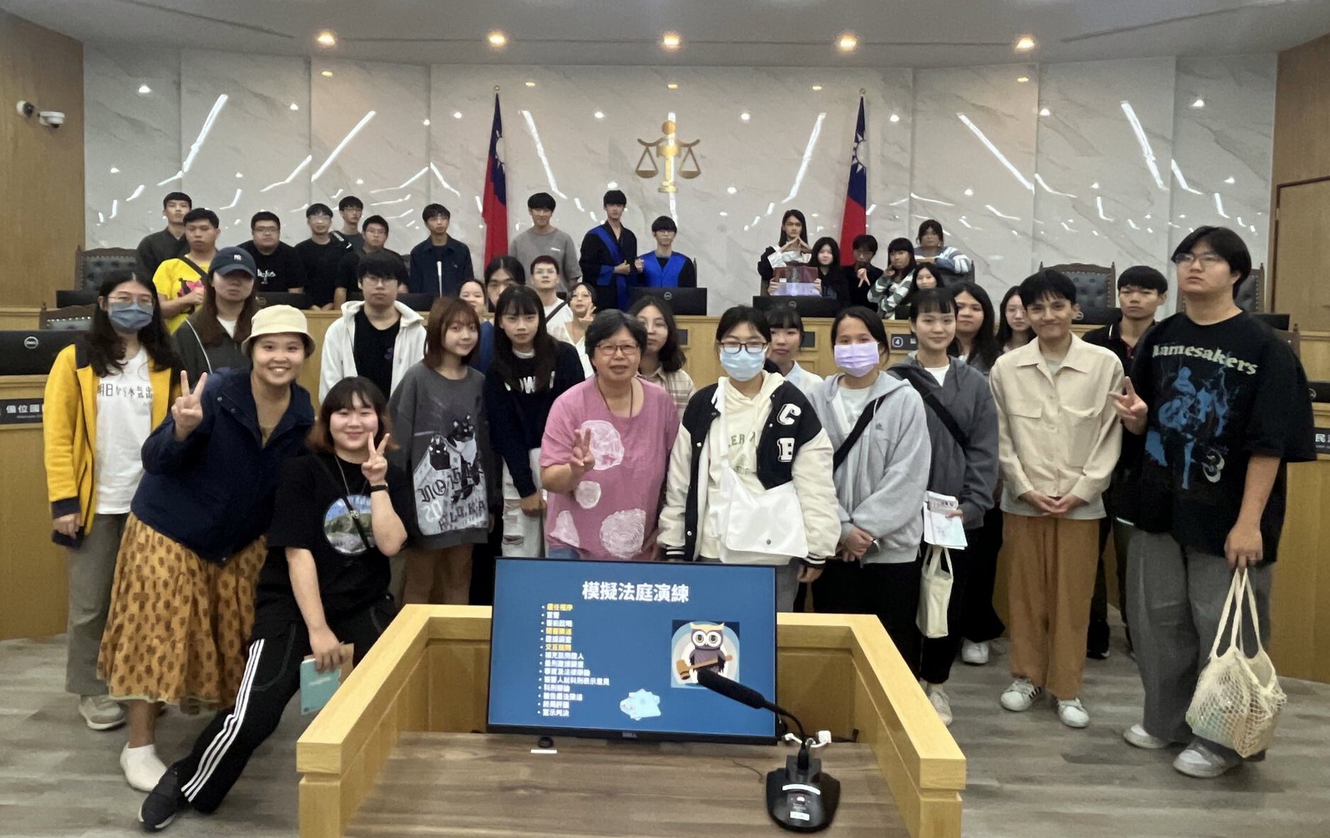 師生於國民法官法庭合影,照片中可以看到有同學仍穿著法袍留影