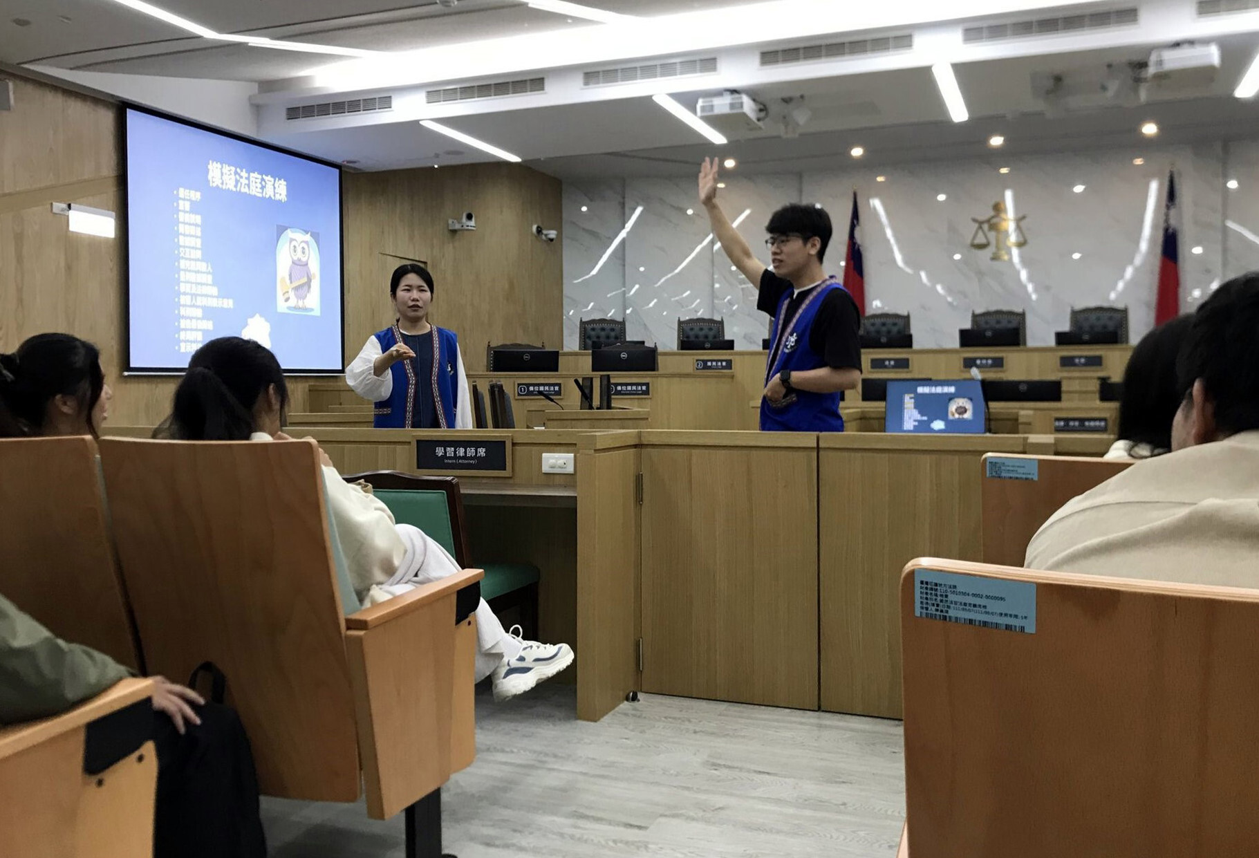 法官助理李思蓉(左邊站立者)與執達員李維佳(中間舉手者)徵求要擔任法官、檢察官等自願者
