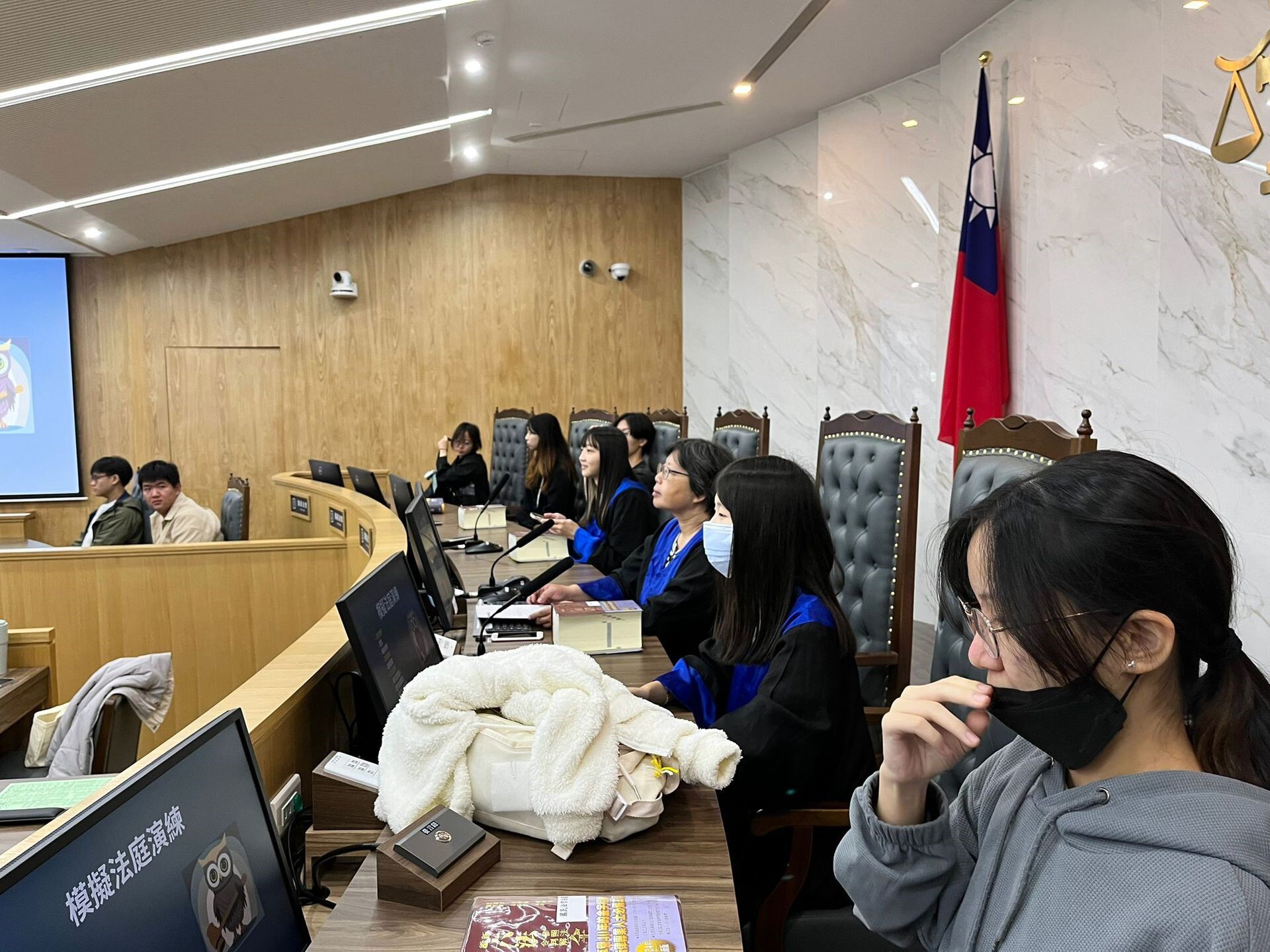 國民法官法庭的座位配置是6位國民法官與3位職業法官(穿法袍者)坐在最高一排,平起平坐