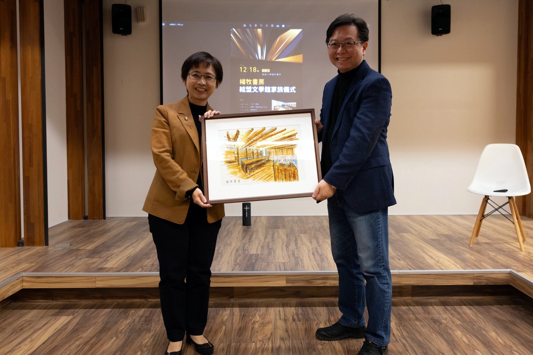 由(左)臺文館長陳瑩芳代表致贈(右)楊牧文學研究中心主任許又方結盟館舍專屬畫作一幅