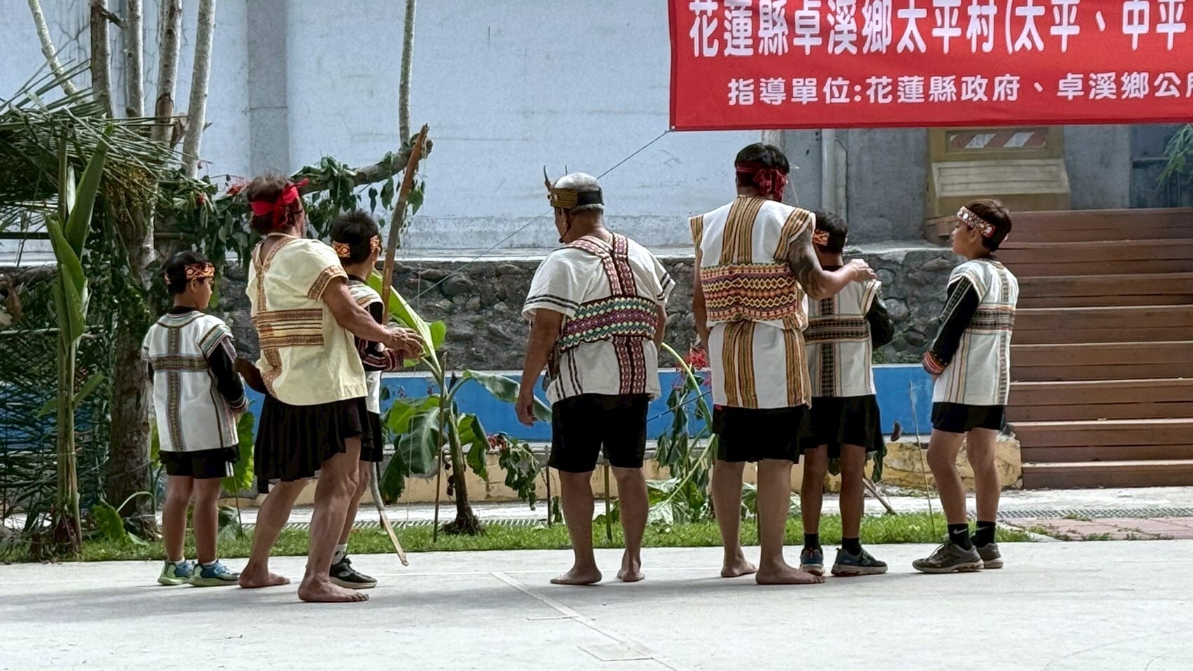 部落族人帶領孩童進行射耳儀式