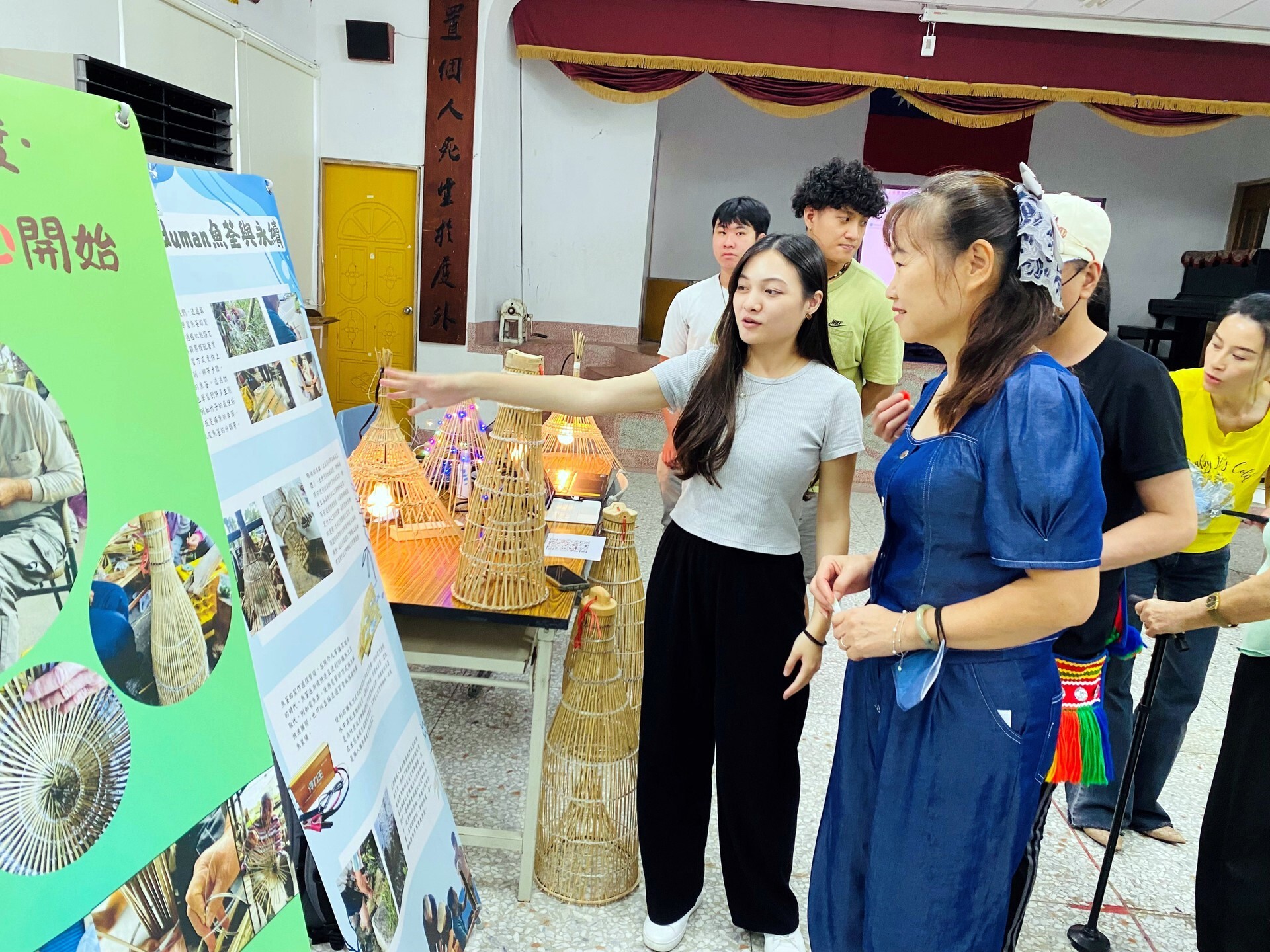 學生向自由瀏覽攤位的居民說明部落魚荃文化和環境永續的關係