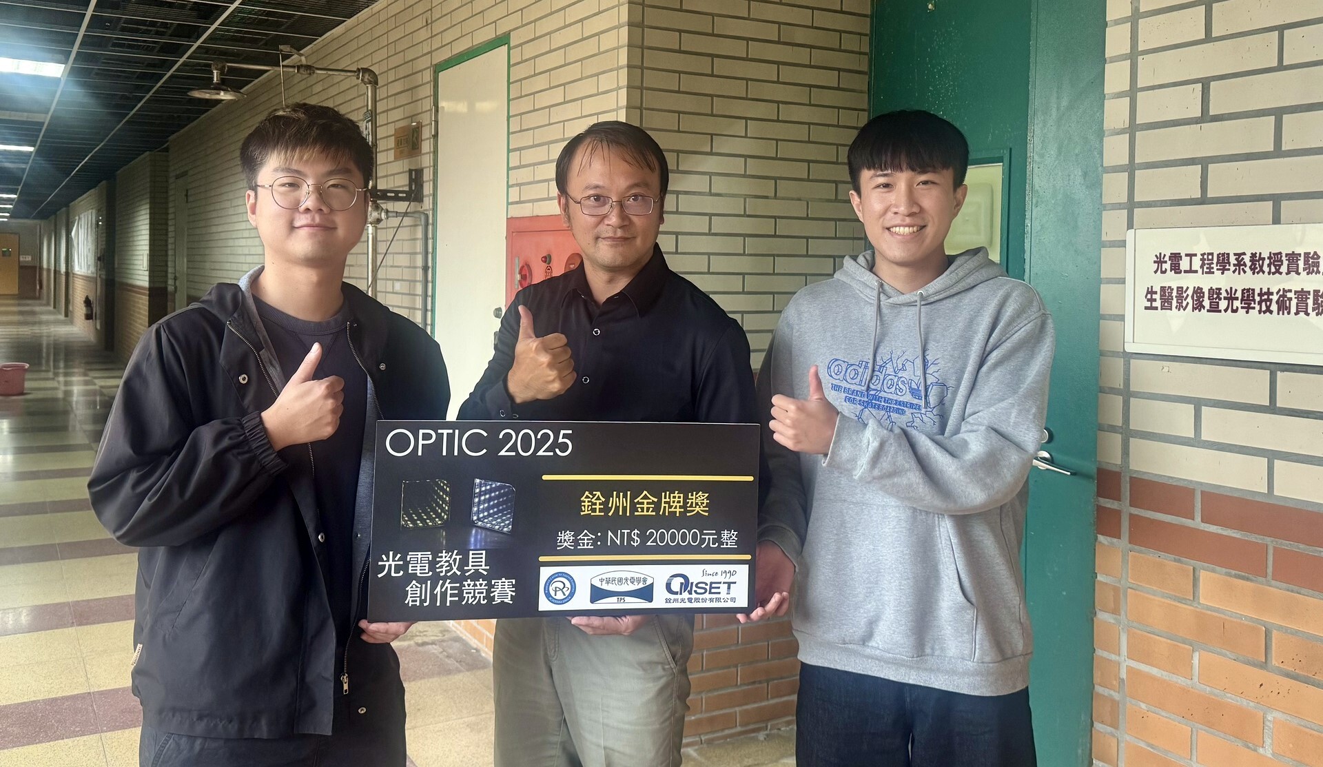 國立東華大學光電工程學系張愷倫(左)、林柏安(右)與指導教授莊沁融(中)合影,展示本次奪得 OPTIC 2025 光電教具創作競賽金牌的作品「異譜光盒」