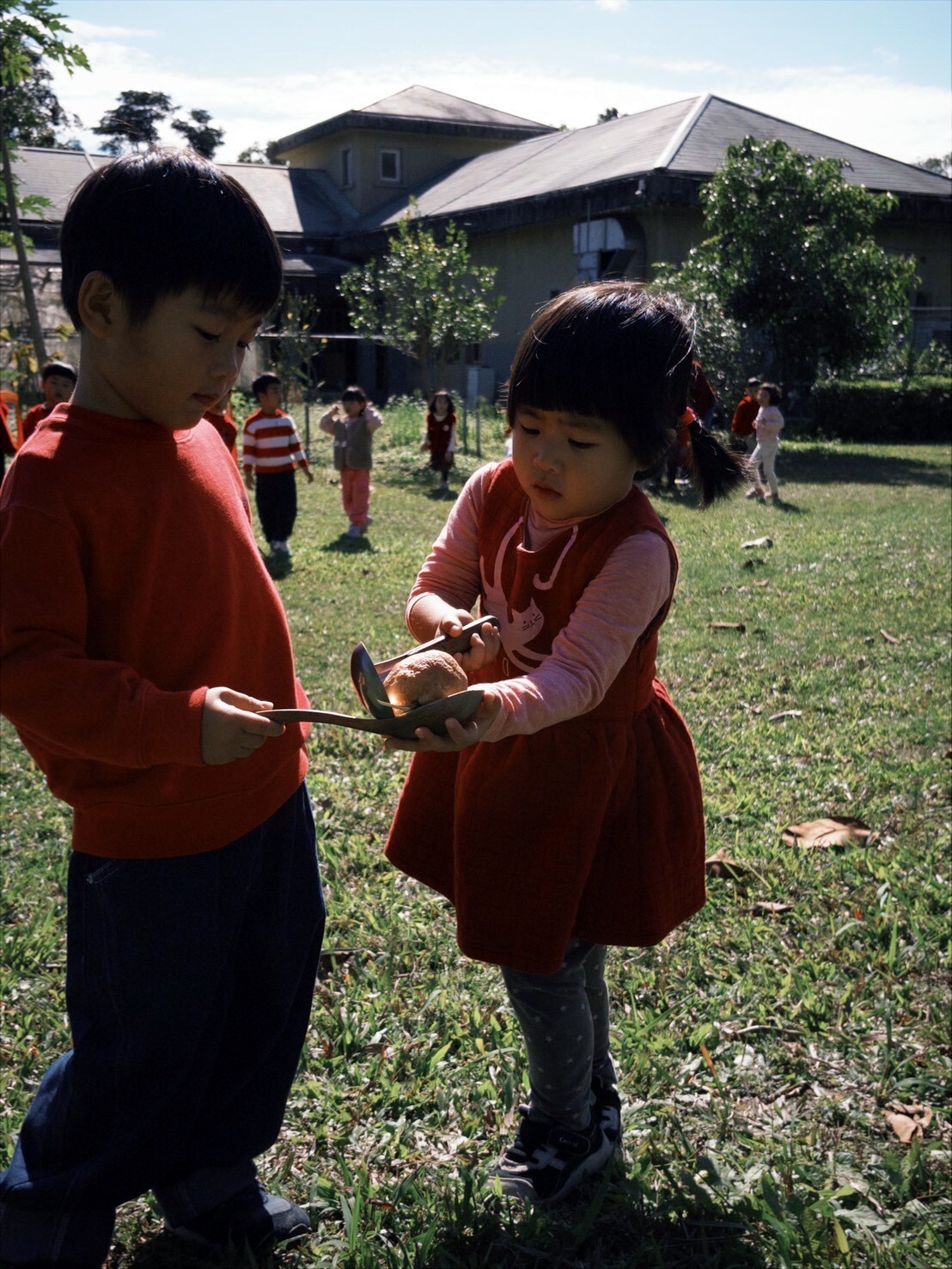 幼兒在「大吉大利」關卡中專注傳接橘子,於合作中體驗吉祥圓滿的年節寓意